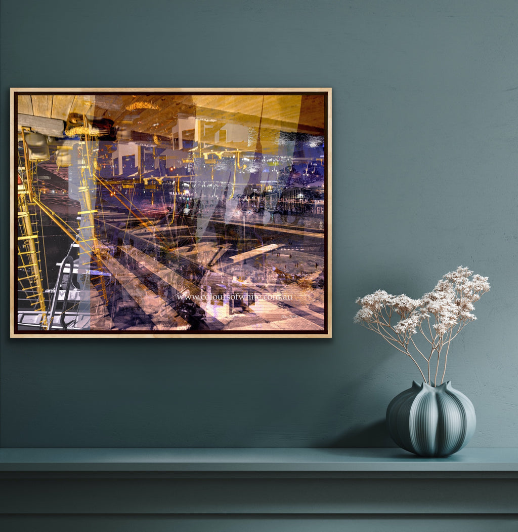 "Keeping Up a Pier Glance 3" box framed ChromaLuxe metal print by Durham J White, featuring a layered photographic artwork of the Mornington waterfront with a boat loading dock and pier in earthy purples, sandy caramels, and a glimpse of night sky, shown in a refined teal blue interior.
