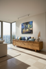 "Melbourne by Night" archival canvas print by Durham J White, shown in a modern living room interior setting above a wooden console table.