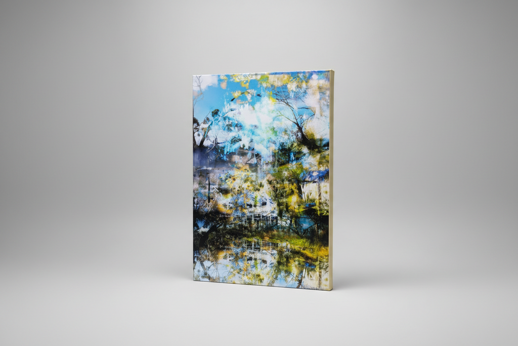 “The Rise” archival canvas art print by Durham J White, featuring a layered photographic artwork of Kyneton's Royal George Hotel reflected in an illusionary waterbody, in pristine sky blues, deep architectural shades, and natural surrounds.