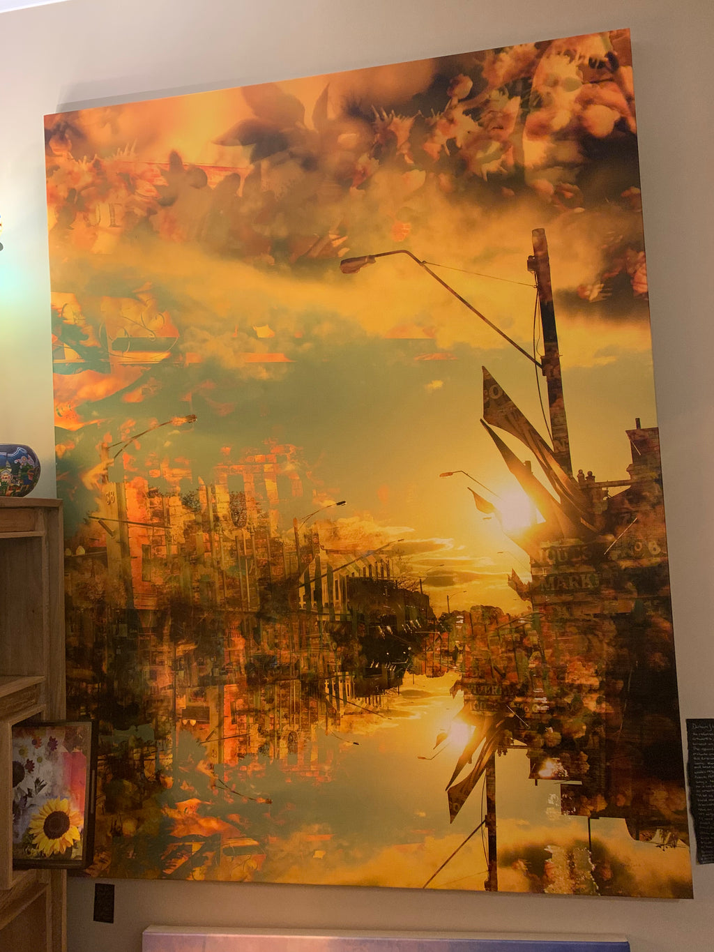 Large semi abstract layered photographic artwork with warm colours and cityscape elements on a wall.