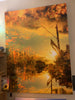 Large semi abstract layered photographic artwork with warm colours and cityscape elements on a wall.