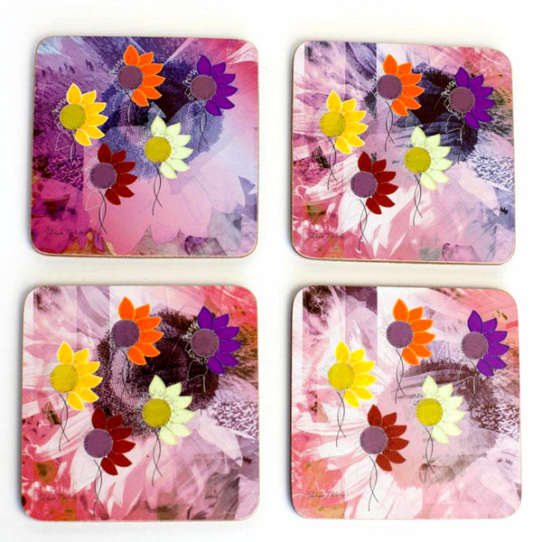 A set of four pink coasters with a sunflower design, featuring vibrant yellow, orange, and purple accents.