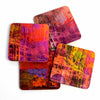 A set of four square coasters featuring Melbourne city elements with a vibrant, abstract design in purple, orange, and pink hues, featuring neon-like light patterns.