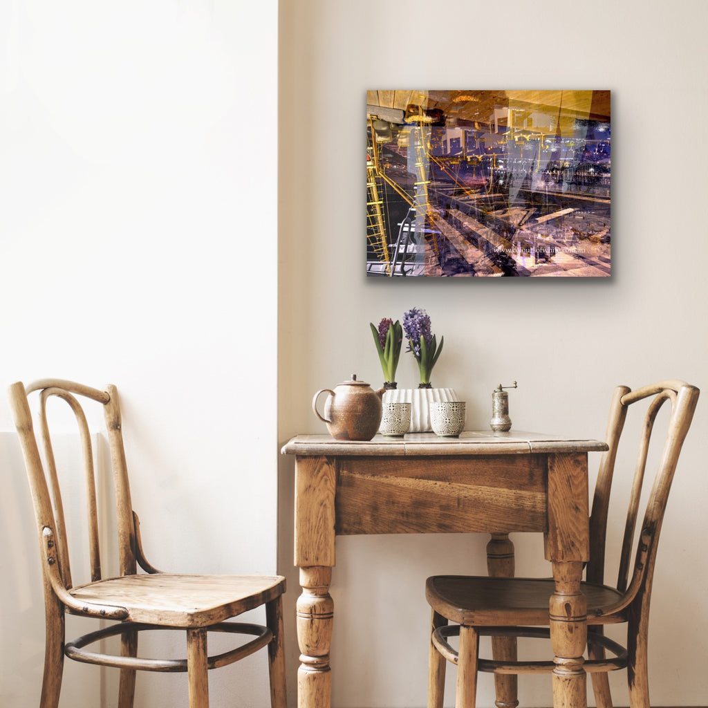 "Keeping Up a Pier Glance 3" archival canvas print by Durham J White, featuring a layered photographic artwork of the Mornington waterfront with a boat loading dock and pier in earthy purples, sandy caramels, and a glimpse of night sky, shown in a beige quaint interior.