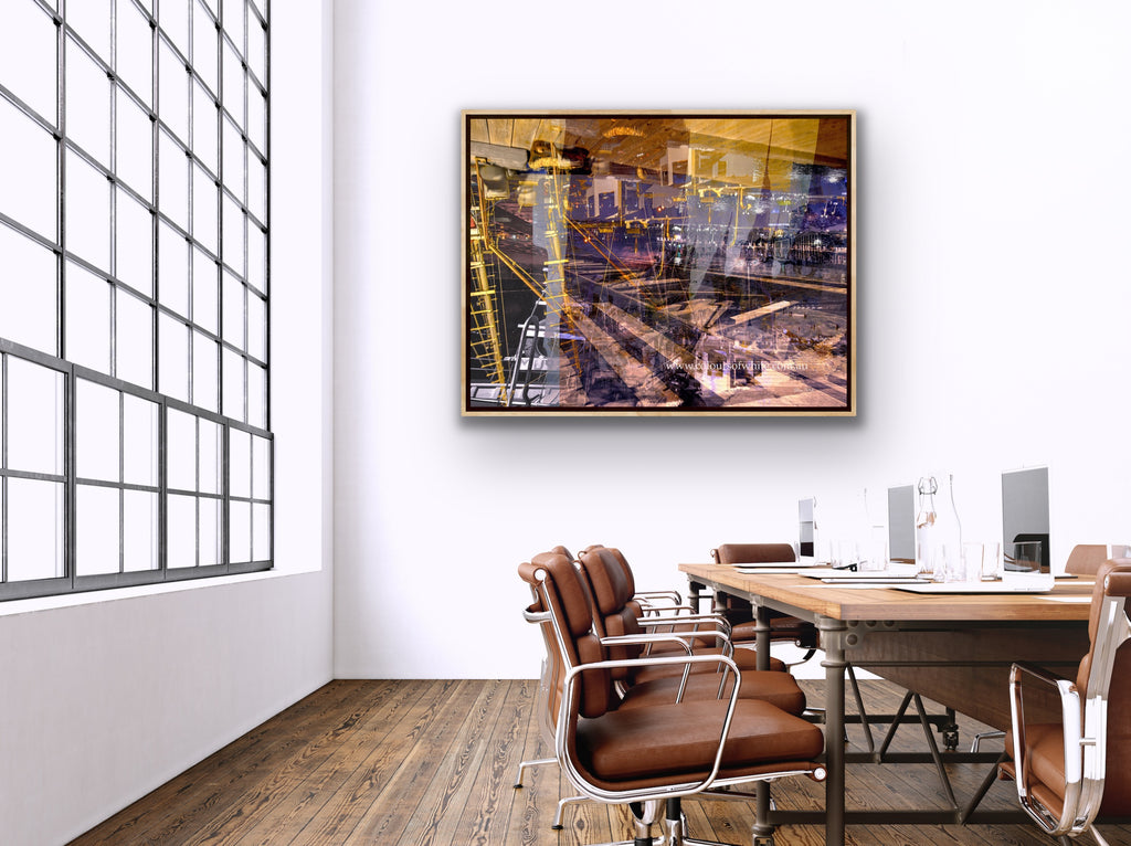 "Keeping Up a Pier Glance 3" box framed archival canvas print by Durham J White, featuring a layered photographic artwork of the Mornington waterfront with a boat loading dock and pier in earthy purples, sandy caramels, and a glimpse of night sky, shown in a large open industrial office space.
