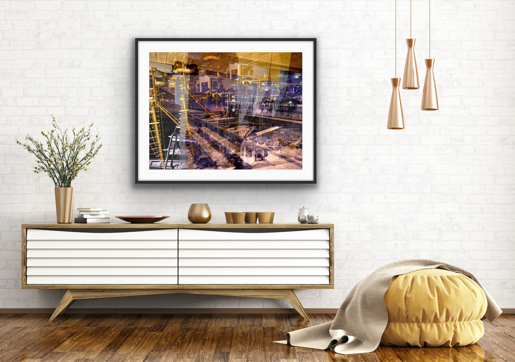 “Keeping Up a Pier Glance 3” glass-framed fine art print by Durham J White, featuring a layered photographic artwork of the Mornington waterfront in deep earthy purples, sandy caramel, and yellow-brown structural accents styled in a white open interior setting.