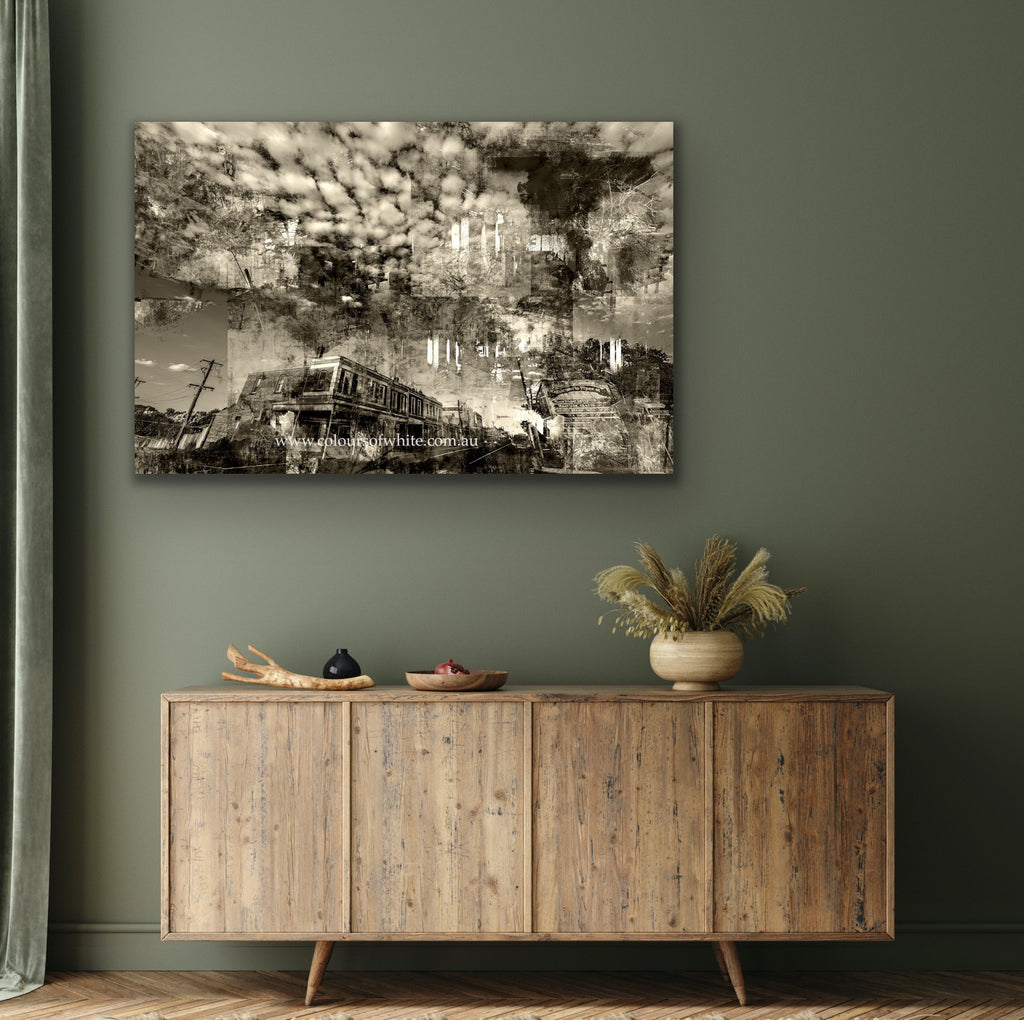 "Shades of the Historical Present Past" Chromaluxe metal print by Durham J White, featuring a semi-abstract layered photographic artwork of Piper Street, Kyneton, with dramatic clouds, rich greys, crisp whites, and deep ink blacks. Styled in a sage green interior.