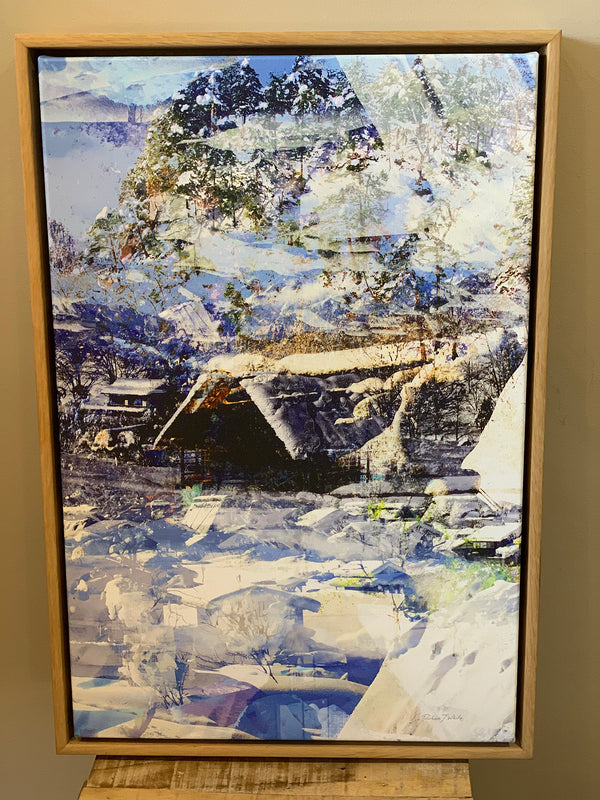 “Snow Caps” box framed archival canvas print by Durham J White, featuring a Japanese winter landscape artwork of snow-covered thatched huts in icy blues, cool whites, and dark timber browns.