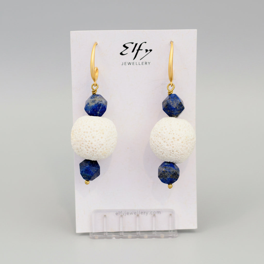 A pair of gold-plated hook earrings with blue lapis and white volcanic rock balls