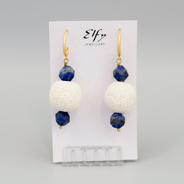 A pair of gold-plated hook earrings with blue lapis and white volcanic rock balls
