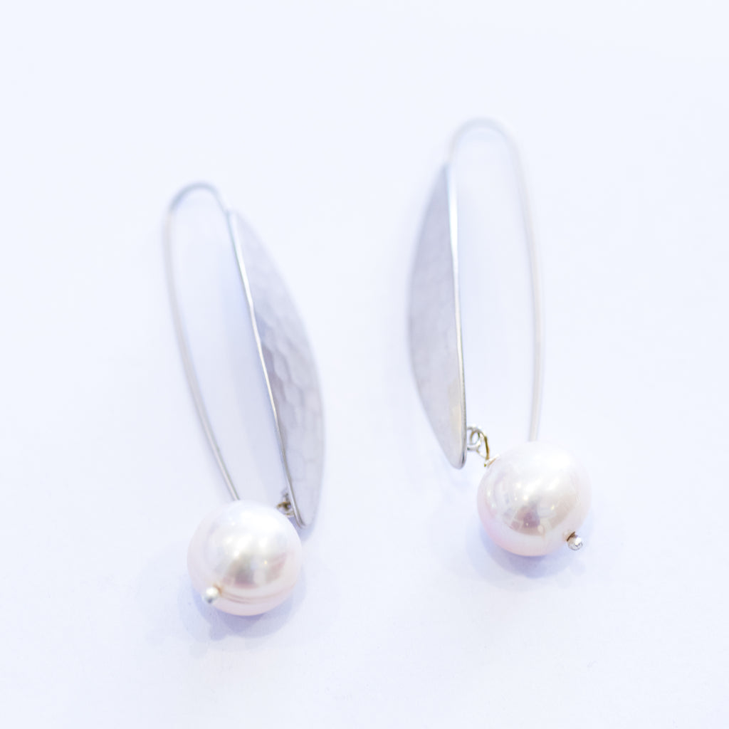 A pair of silver leaf earrings with a single freshwater pearl on each hook.