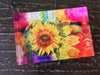 A vibrant, multicoloured artwork featuring a FleuroSun Summer Spray sunflower in a stylized, psychedelic style on a rectangular free standing tile.