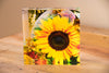 A square tile with a retro psychedelic design featuring a multicolored sunflower in the center, with an abstract background.
