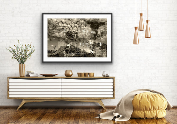 An industrial feeling layered photographic artwork that features the historical Piper Street, Kyneton in a semi-abstract way. Epic clouds. Fine Art glass framed print featured in an open natural white walled and timber floored living space.
