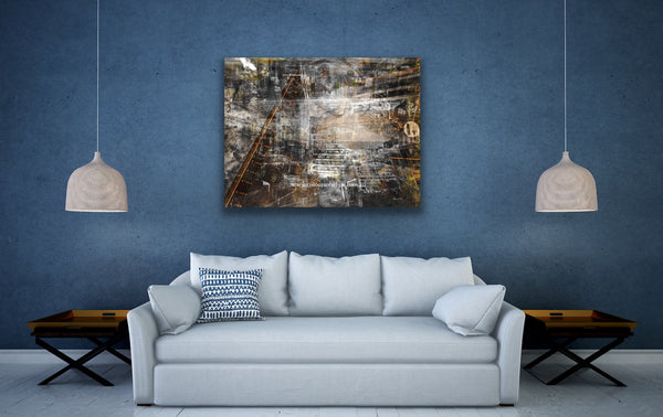 A black and white layered photographic artwork featuring a blurred industrial scene with historical buildings, predominantly in shades of gray, copper tones, and varying perspectives. Feature artwork in a refined blue living space.